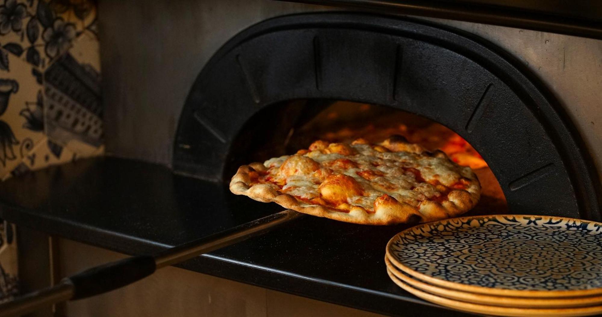 Eme Catedral Mercer Hotel Sevilla Exteriér fotografie Pizza being removed from a wood-fired oven